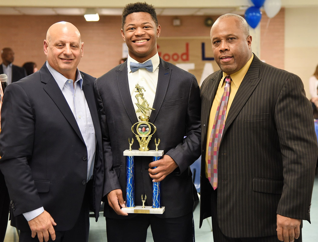Jared Leake with Huntington football coaches Steve Muller and Todd Jamison.