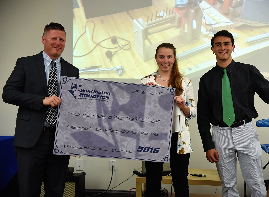 Principal Brenden Cusack holds a comemorative check