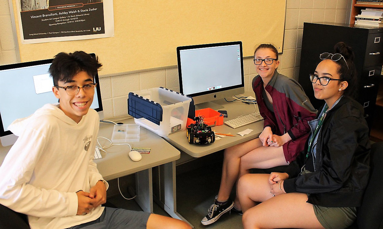 Tim Low with his teammates and their robot in the computer lab. 