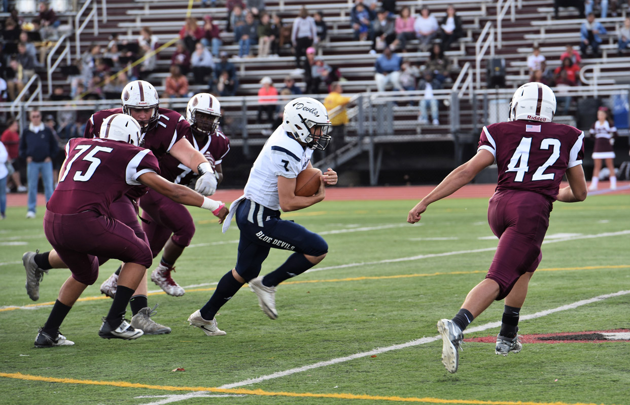 Huntington quarterback John Paci evades four would-be Bay Shore tacklers.