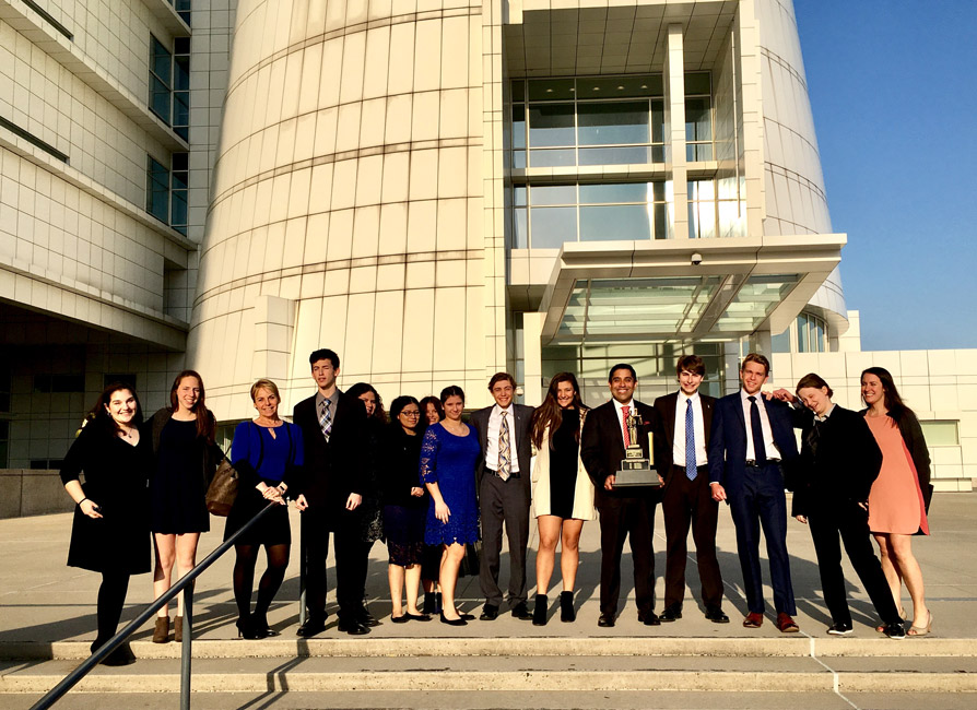 The Huntington team with the county championship trophy on the steps of US District Court in Central Islip.
