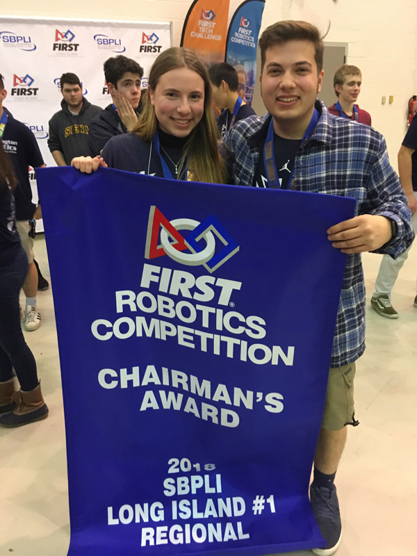 Seniors Lindsay Saginaw and John Riley with the Chairman's Award banner.