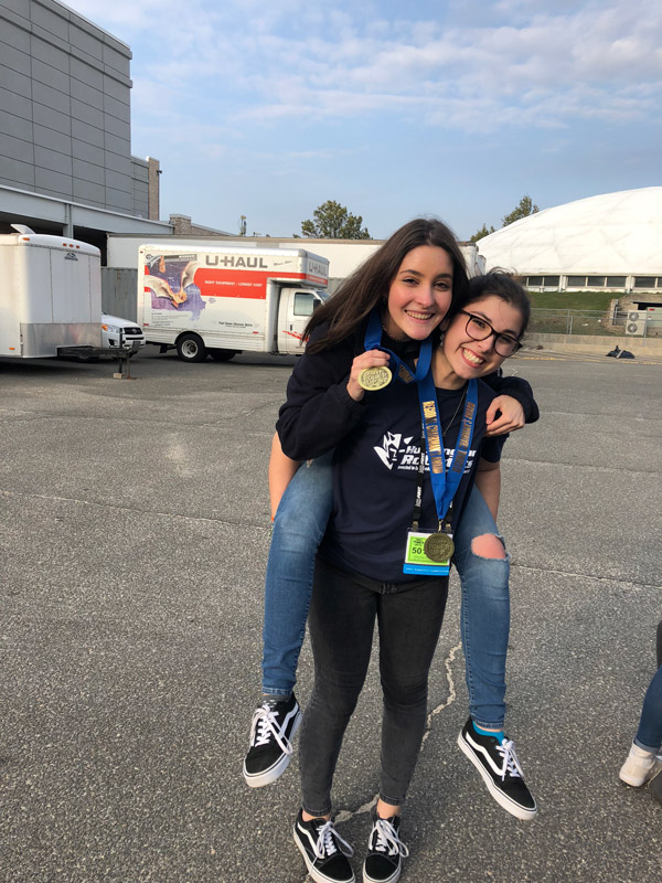 Bella McGinnis (foreground) jokes around with good friend Lauren White outside the robotics regionals at Hofstra Univ.