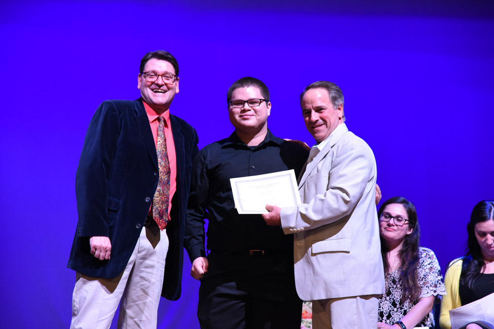 Joel Alfaro is flanked by teacher Mike Schwendemann and Humanities Chairman Joseph Leavy 