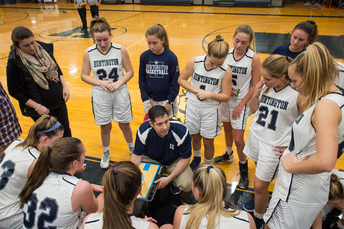 The Huntington girls' basketball team huddles around head coach Mike Kaplan. (Darin Reed photo.)