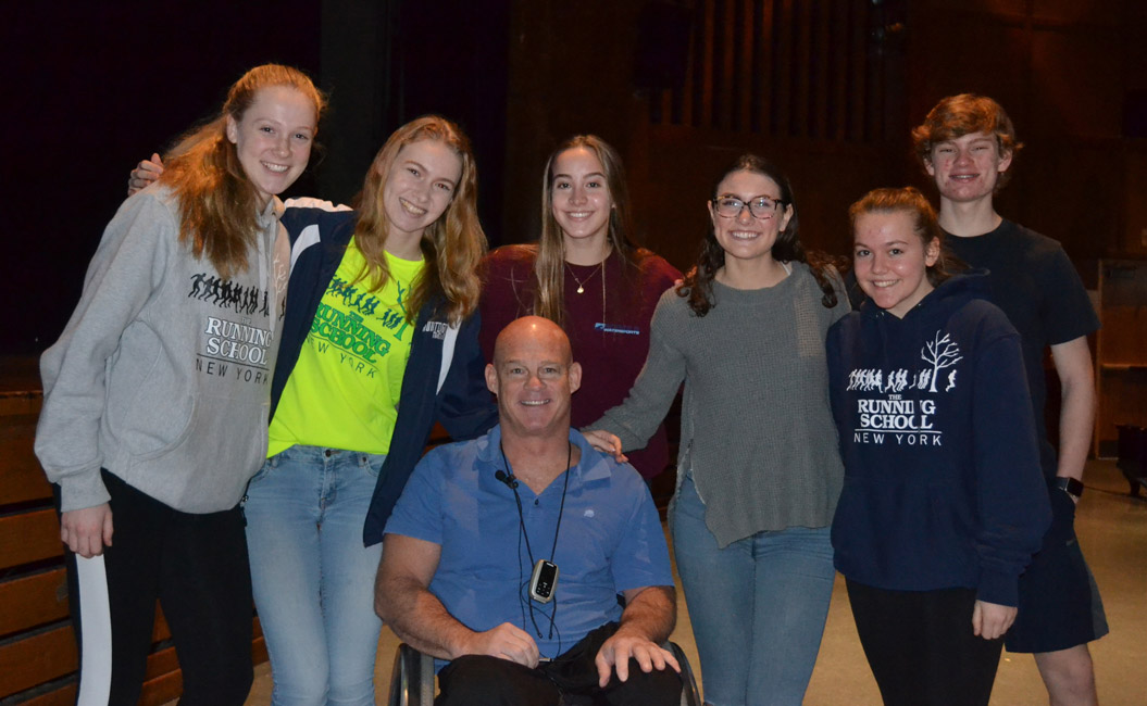 Pete Hawkins is surrounded by Huntington High School students in the auditorium.