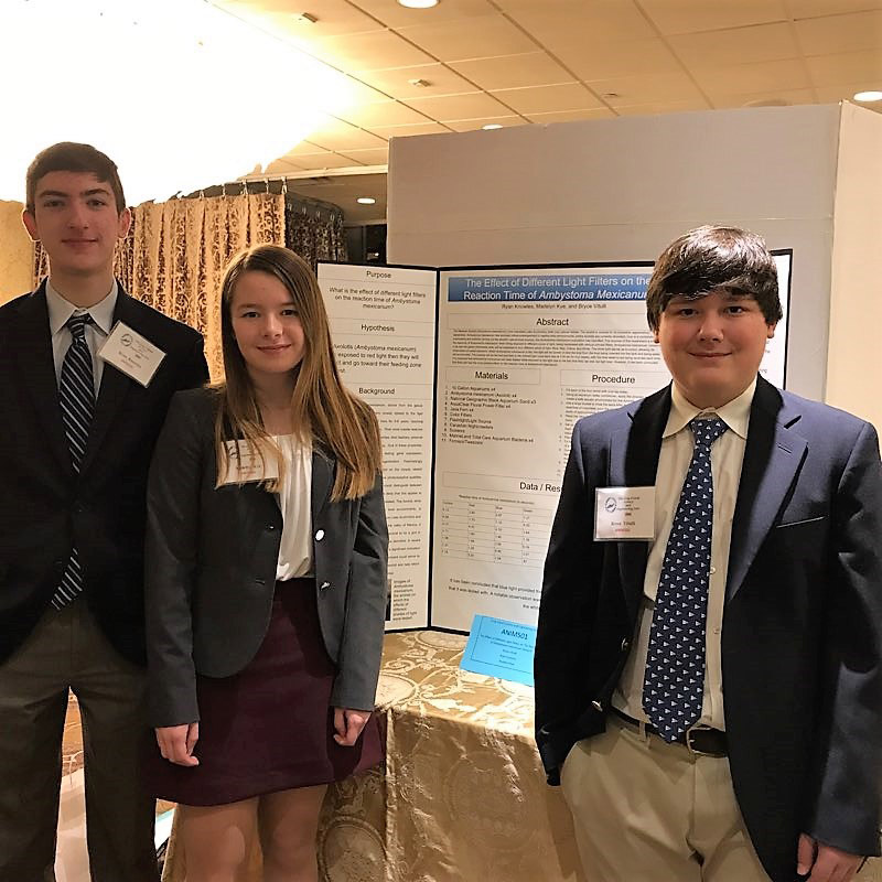 Ryan Knowles, Madelyn Kye and Bryce Vitulli with their research findings at Crest Hollow.