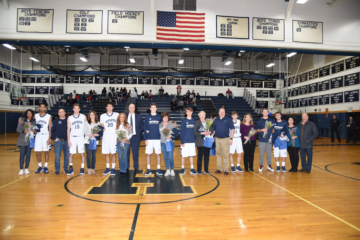 Huntington boys' basketball team seniors and their parents at midcourt late last week. 