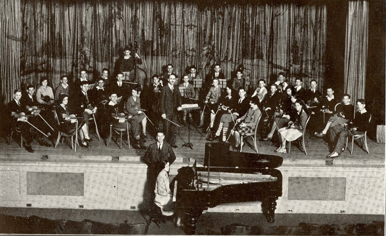 Huntington's 1930 orchestra with director James Cloyd Doty standing with the baton at center.