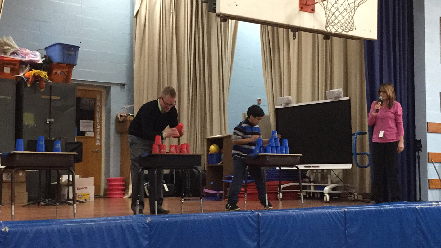 Southdown Principal Scott Oshrin and student Jaipreet Singh engaged in a cup stacking contest. 