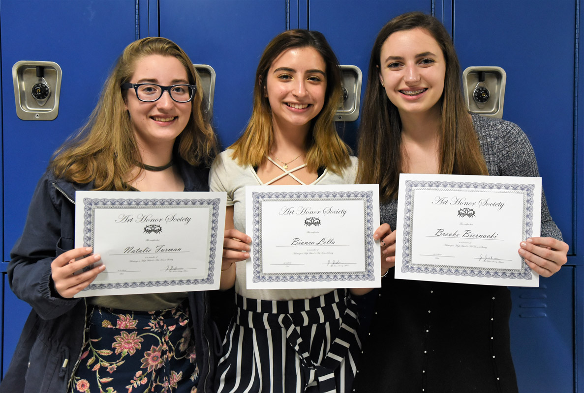 Three of the 33 new inductees proudly display their membership certificates.