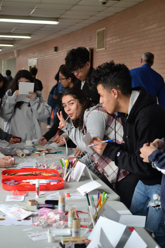 Students lined up at long tables to create the cards and insribed them with heartfelt messages.