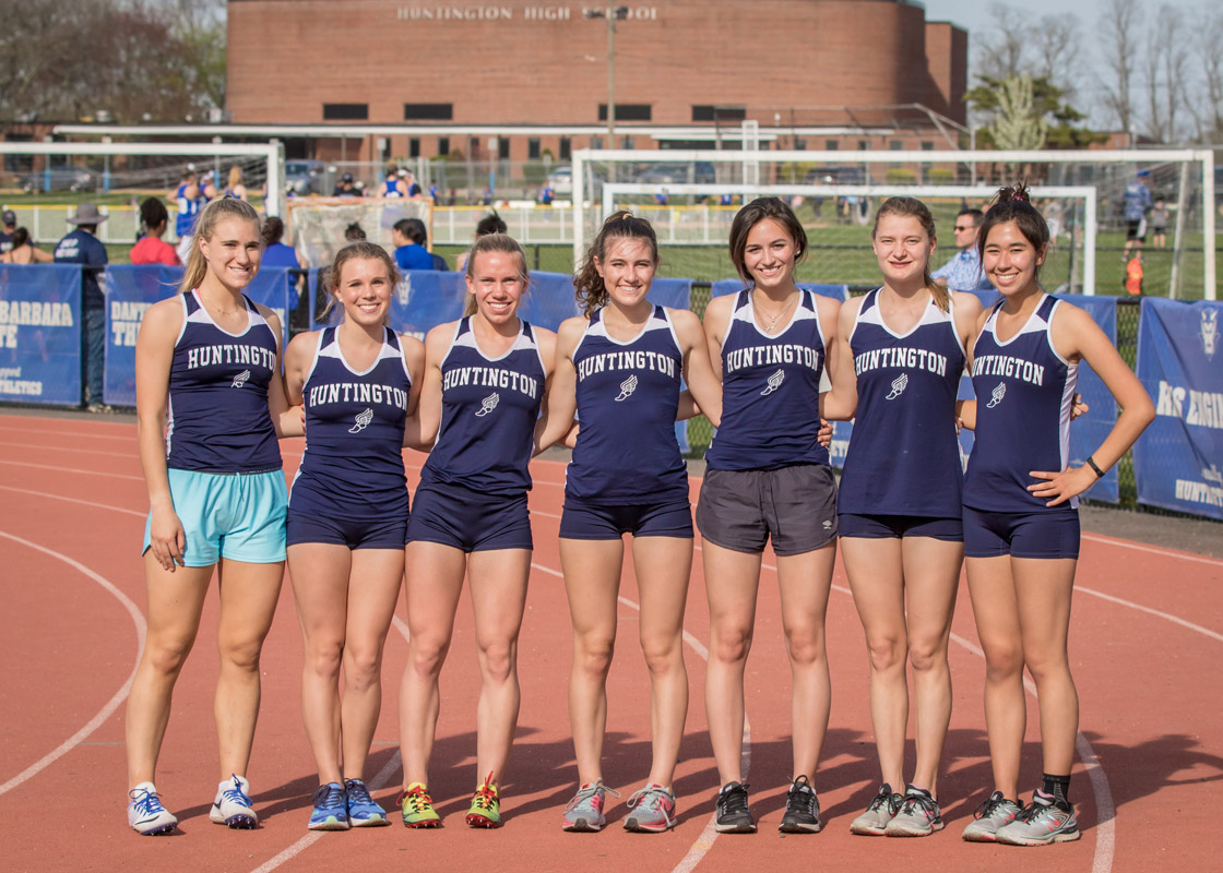 Nicole Arenth (right) with fellow Huntington girls' track seniors. (Mike Connell photo.).