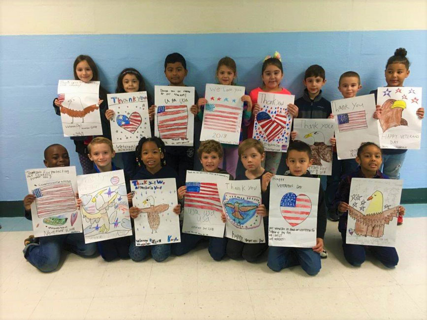 Flower Hill second graders with the posters they created to celebrate local veterans.
