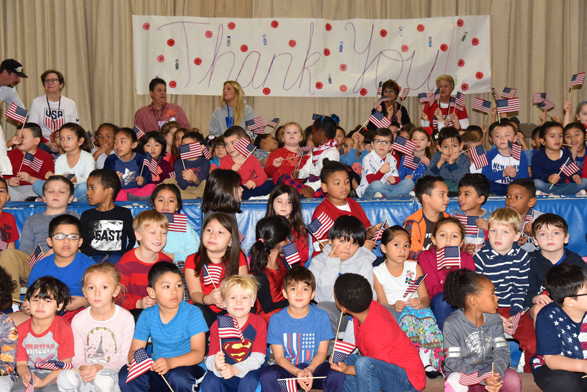 Students sat on or near the stage and recited poems and sang patriotic songs for the crowd. 