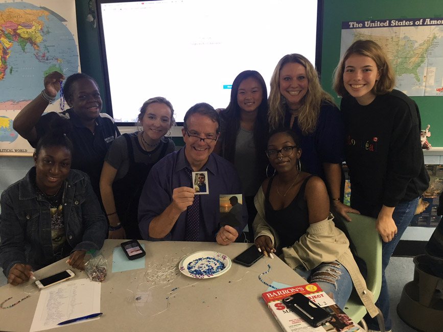 Robert Gilmor III is surrounded by Interact Club members during the rafiki bracelet making session.