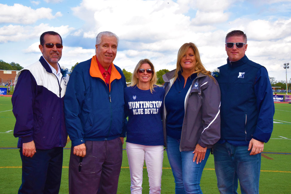 NYS Senator Carl Marcellino (second from left) is flanked by district officials at the Homecoming Day football game 