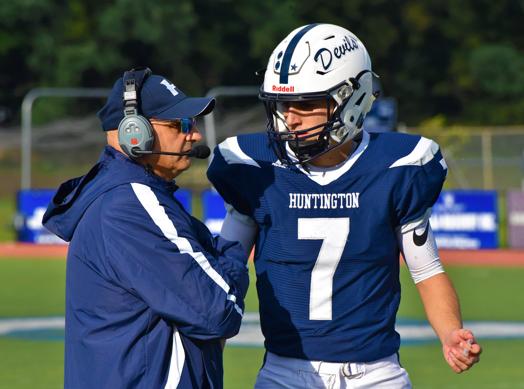 Huntington head coach Steve Muller and quarterback John Paul Paci IV confer on the next play.