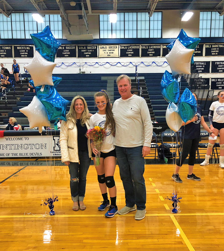 Caroline Lenze with her parents on Senior Day in Louis D. Giani Gymnasium.
