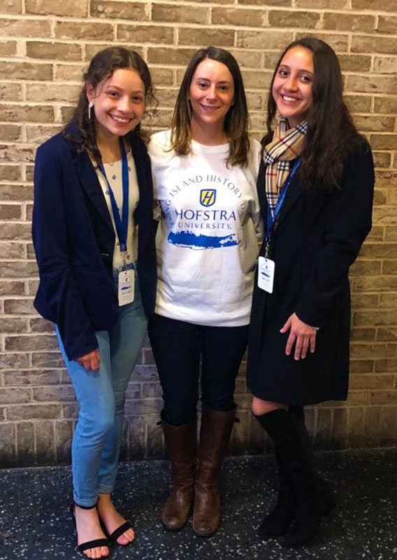 Teacher Lauren Desiderio is flanked by project partners Daniela Weihskopf Escobar and Daniela Ramos at Hofstra University.