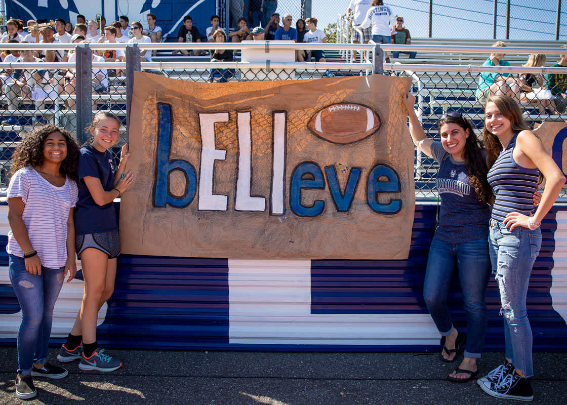 Students near a sign emblazoned with Eli Mollineaux's motto. (Mike Connell photo.)