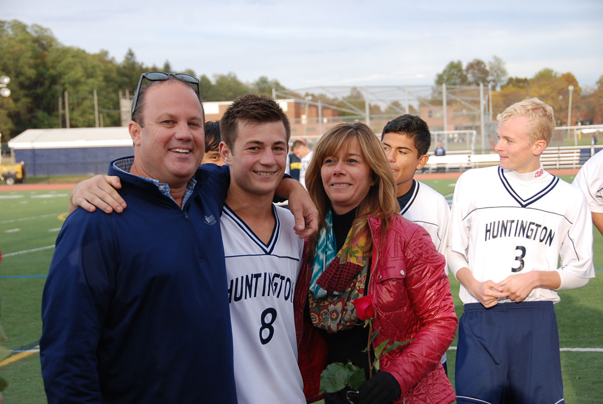 Jeremy Gelb is flanked by his parents on Senior Day at Blue Devil Field.
