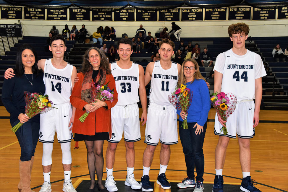 Huntington boys' basketball seniors with their respective mom at midcourt on Senior Day 