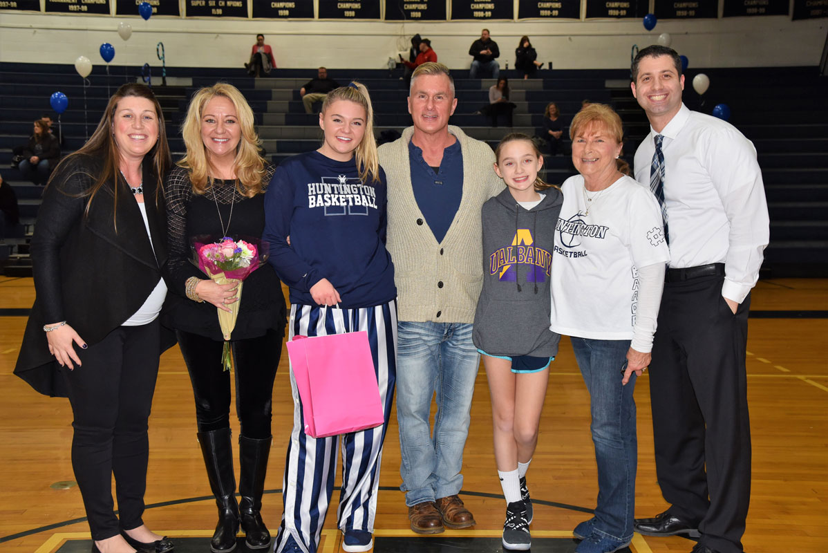 Christie Baade with her family and coaches on Huntington girls' basketball Senior Day 