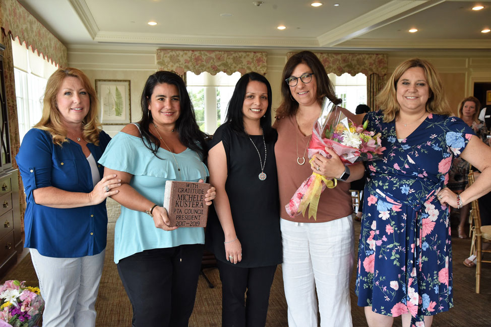 Retiring PTA Council President Michele Kustera (holding bouquet) is surrounded by her colleagues at the group's annual luncheon