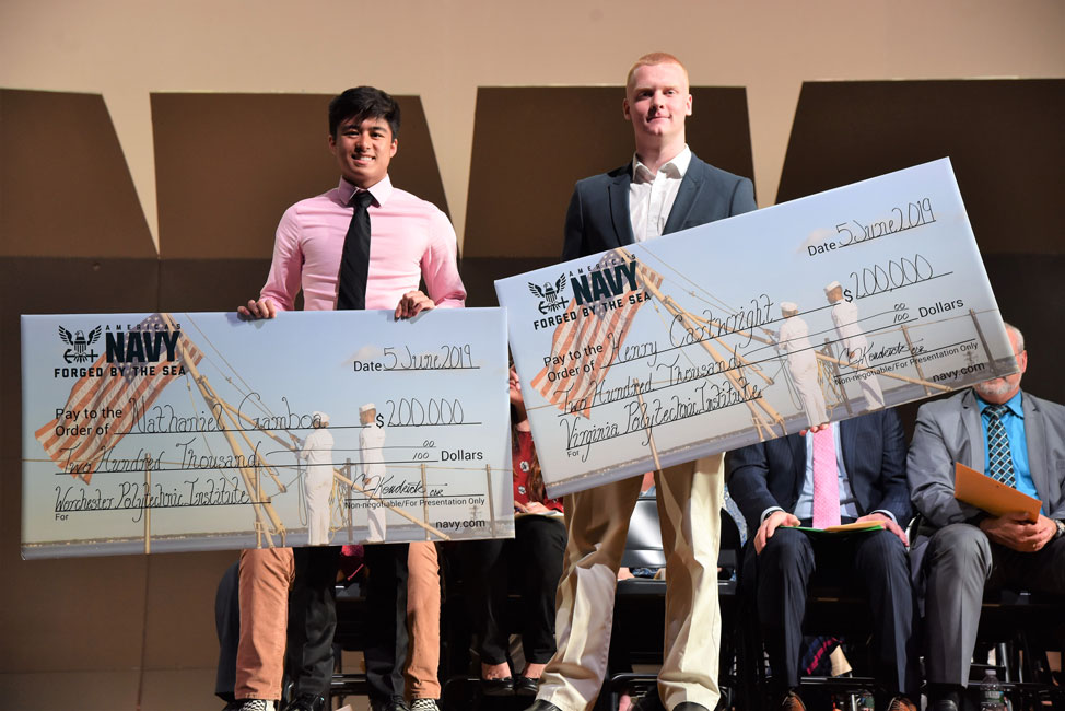 Huntington Class of 2019 members Nathaniel Gamboa and Henry Cartwright hold mock NROTC checks at the senior academic awards ceremony 
