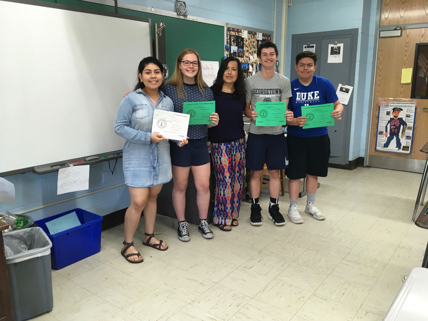 Huntington Spanish teacher Mercedes Pena is flanked on either side by Victor Baptiste essay contest honorees.