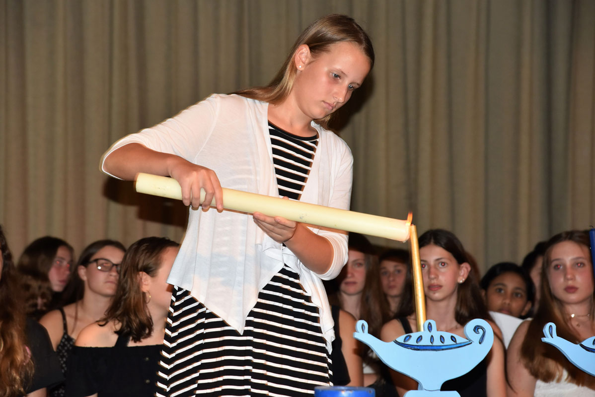 Finley eighth grader Sarah Krisch light five candles signifying each of the honor society's ideals.