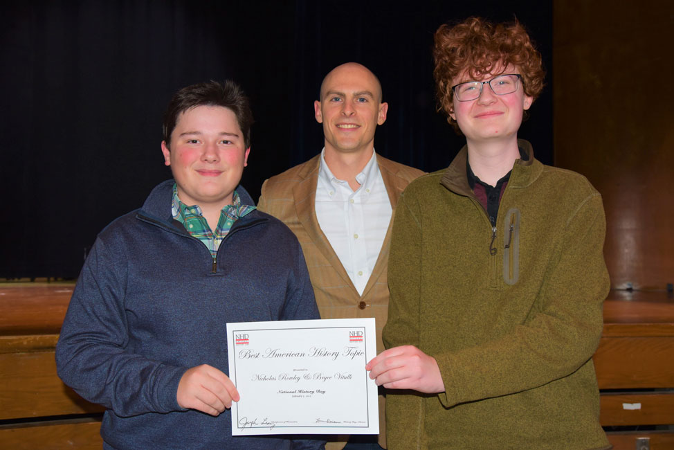 Huntington social studies teacher Kenneth Donovan is flanked by Bryce Vitulli and Nicholas Rowley 