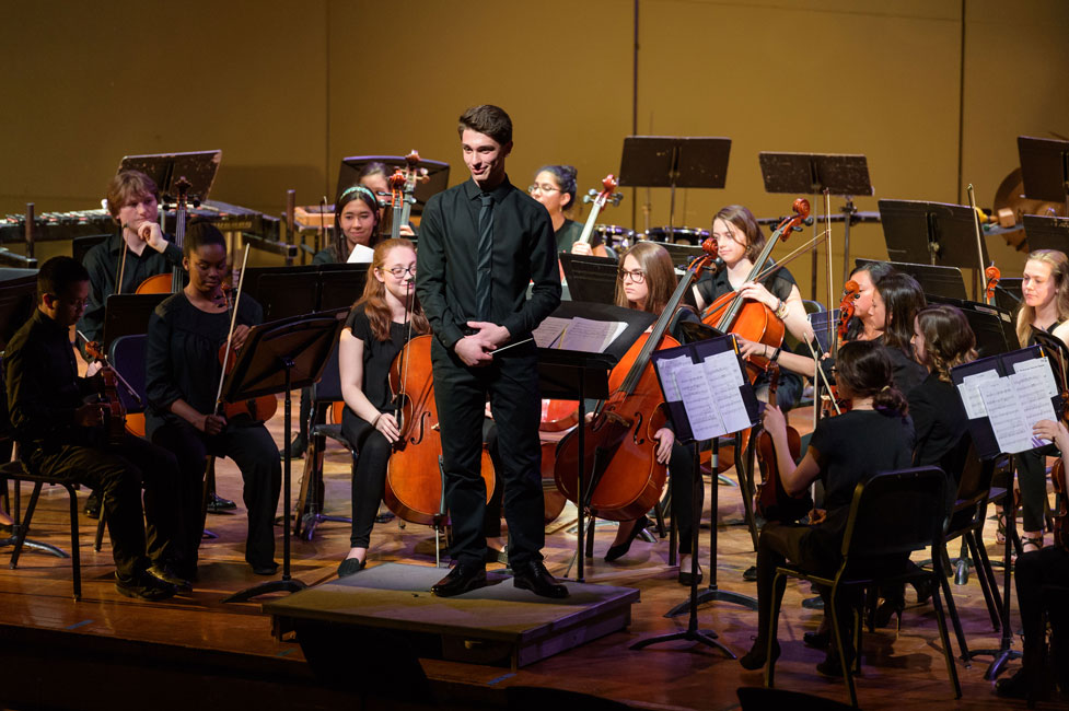 Julien Rentsch directs the high school orchestra as it performs one of his original compositions. (Darin Reed photo