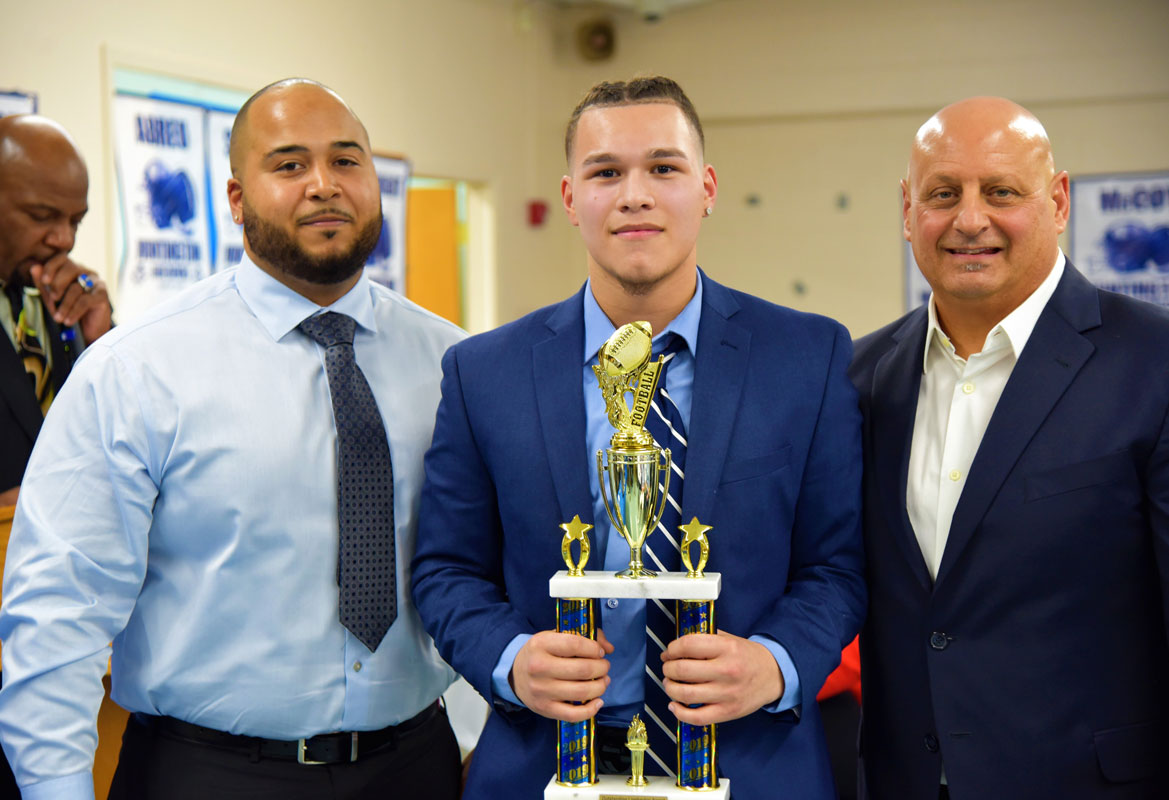 Outstanding Linebacker Award recipient Joey Ramos with coaches Eddie Santos and Steve Muller