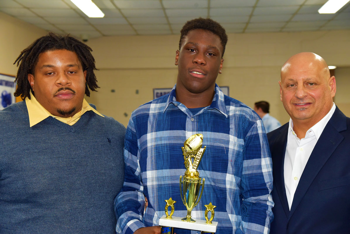 Outstanding Defensive Lineman Award honoree with coaches Andrew White and Steve Muller