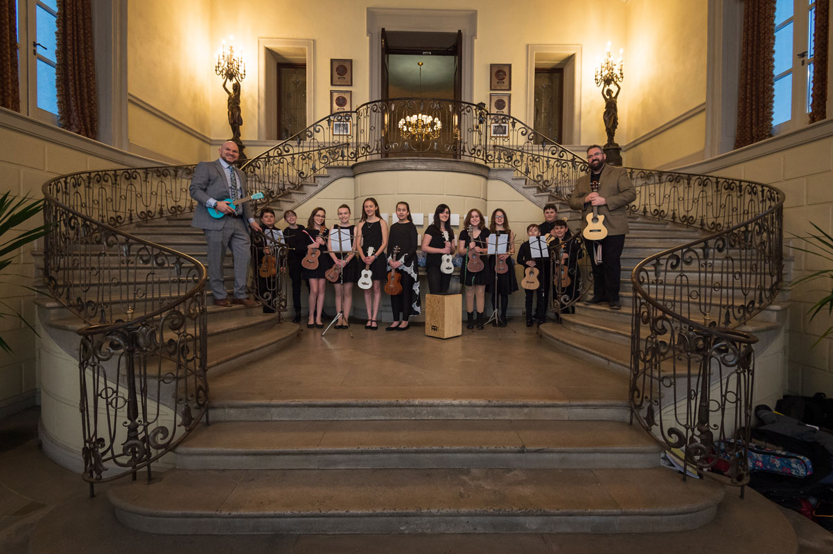Finley music teachers Frank Battista and Matt Gelfer flank ukulele club members who entertained arriving guests at OHEKA. (Darin Reed photo.)