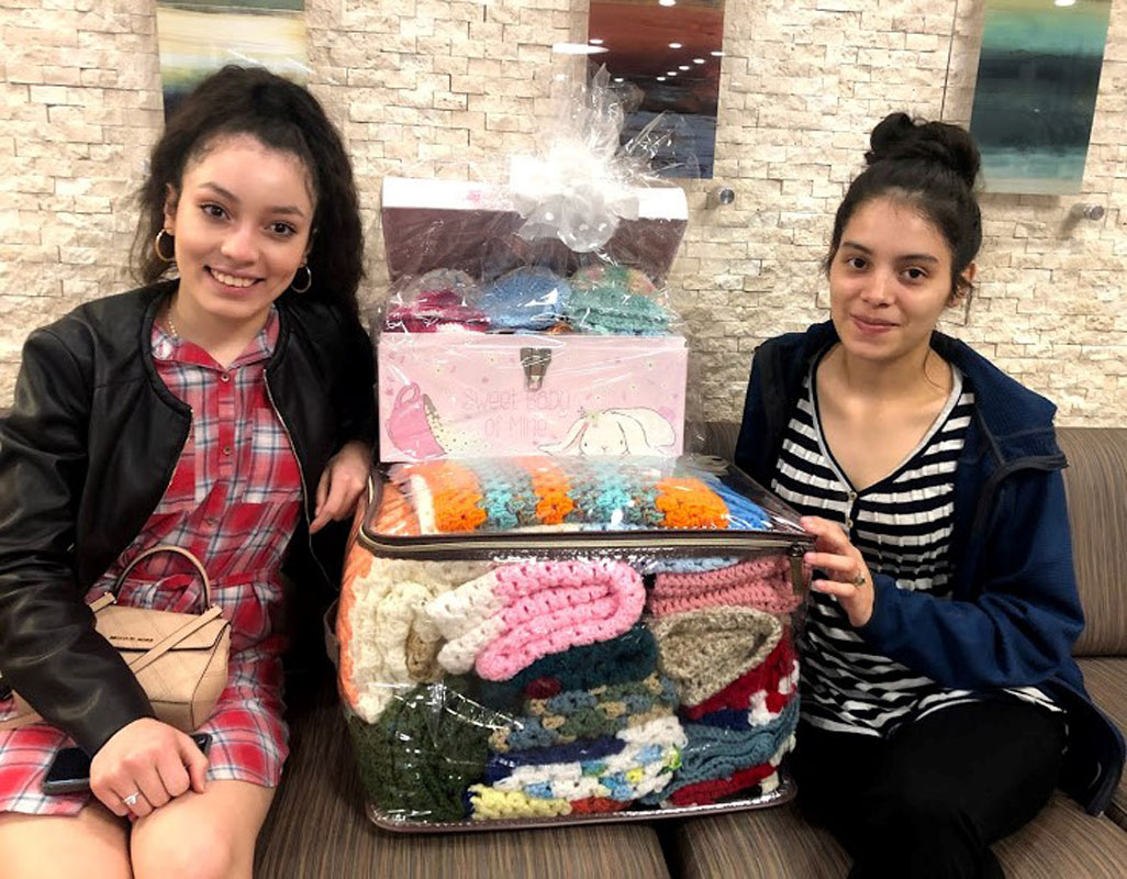Ilsi Martinez Euceda and Yessy Bonilla Lainez with crocheted items at St. Catherine of Siena Medical Center.