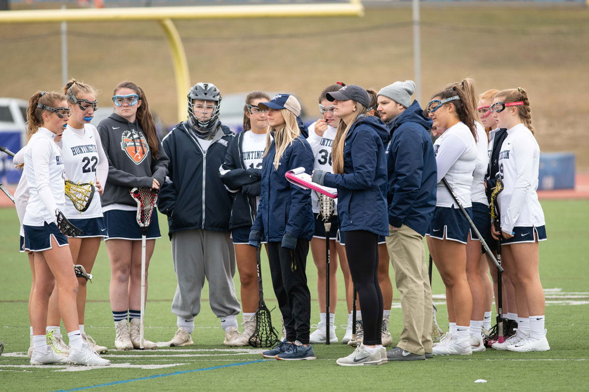 The Huntington varsity girls' lacrosse team huddles with the Blue Devils' coaches. (Darin Reed photo.)