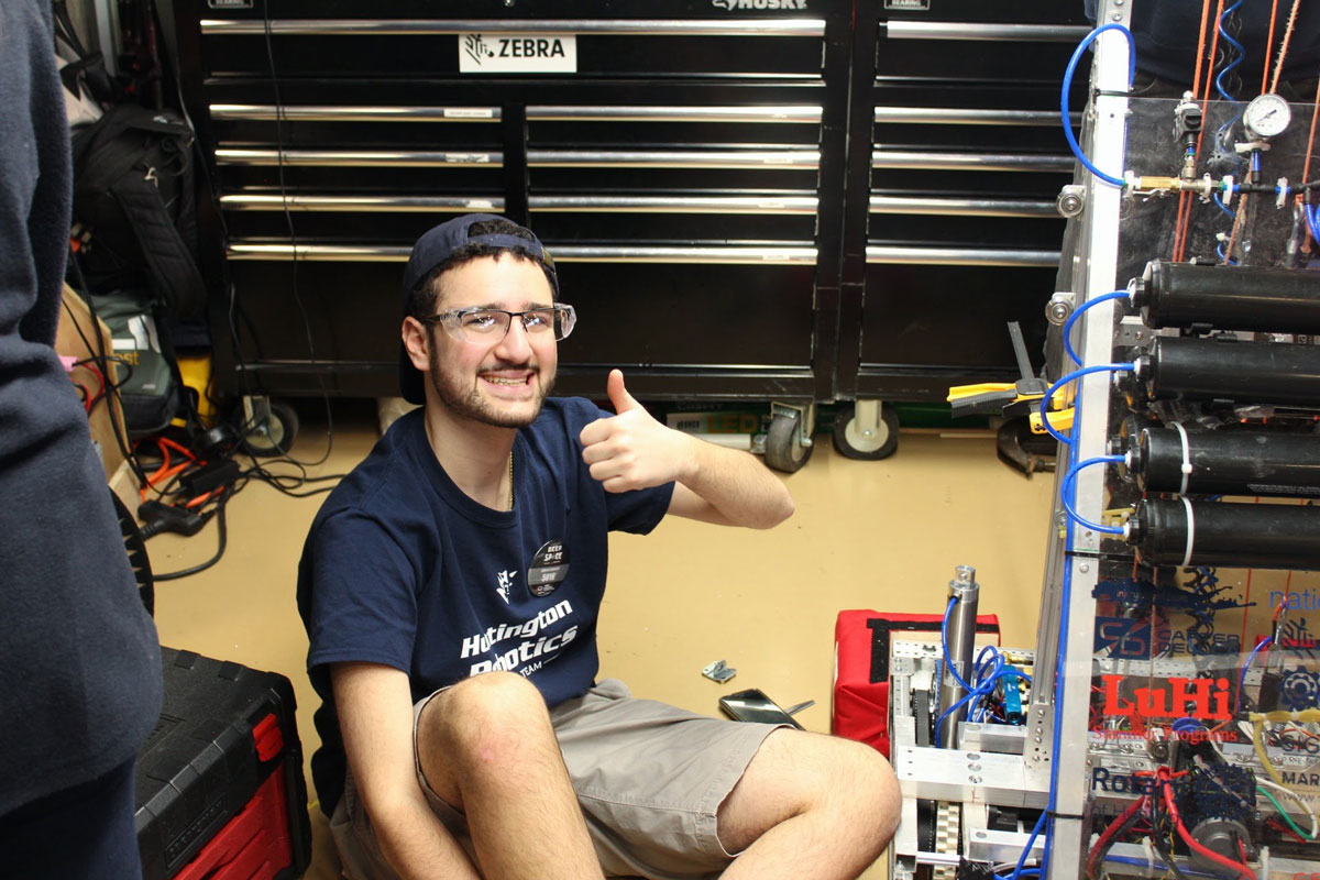 David Mosden gives a thumbs-up sign in the pit at a Huntington Robotics competition.