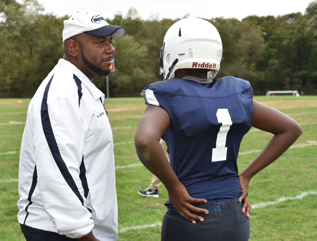 Finley head coach Ron Wilson and quarterback Jayden Taylor compare notes during a game.