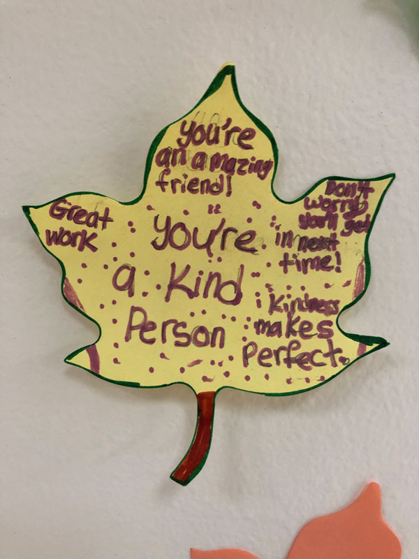 Woodhull students are writing encouraging words and phrases on leaves and posting them on a hallway tree.