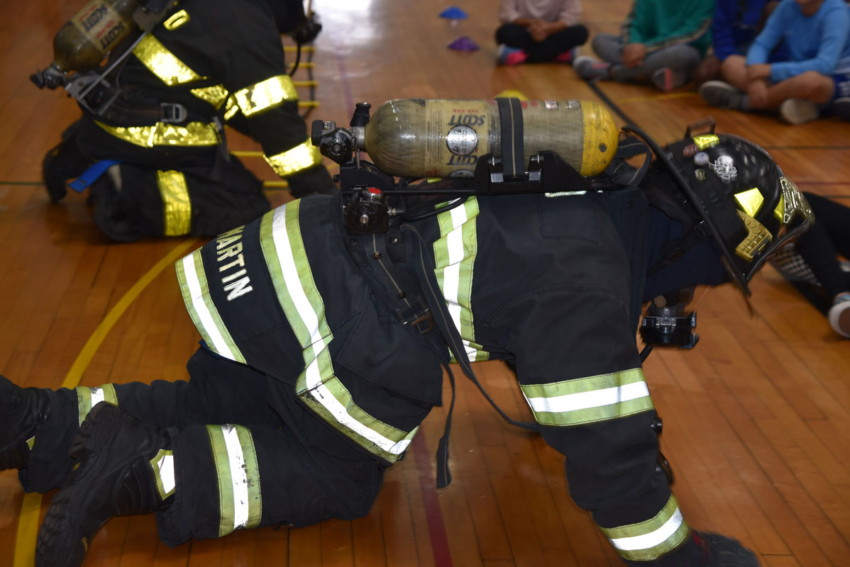 Firemen donned their emergency gear and demonstrated what they would do and say in a smoke filled house 