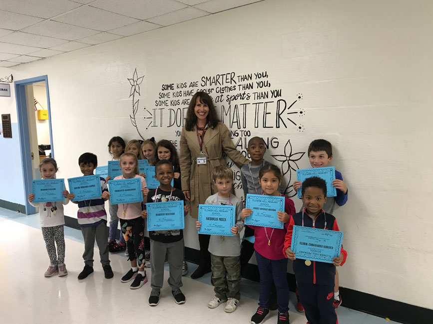 Principal Lucia Laguarda with Flower Hill's award winning students.