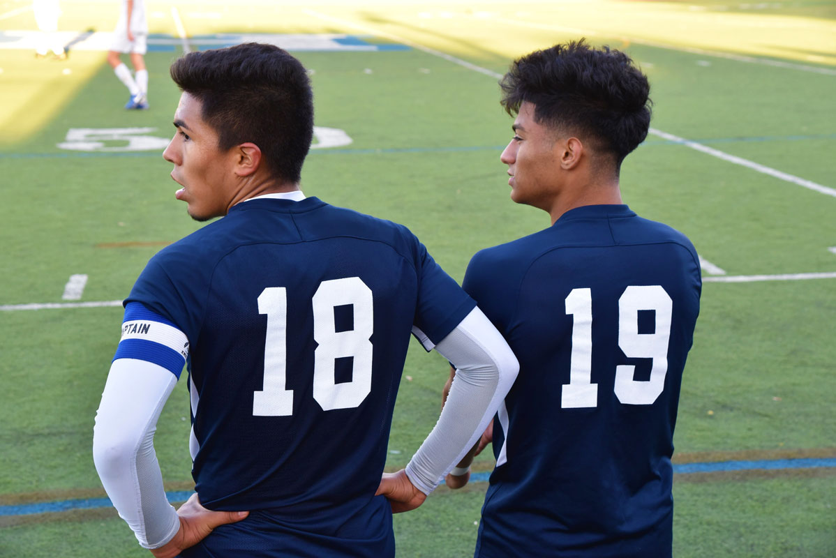 Seniors Brian Contreras and Carlos Reyes wait to go back into the game after taking a breather.