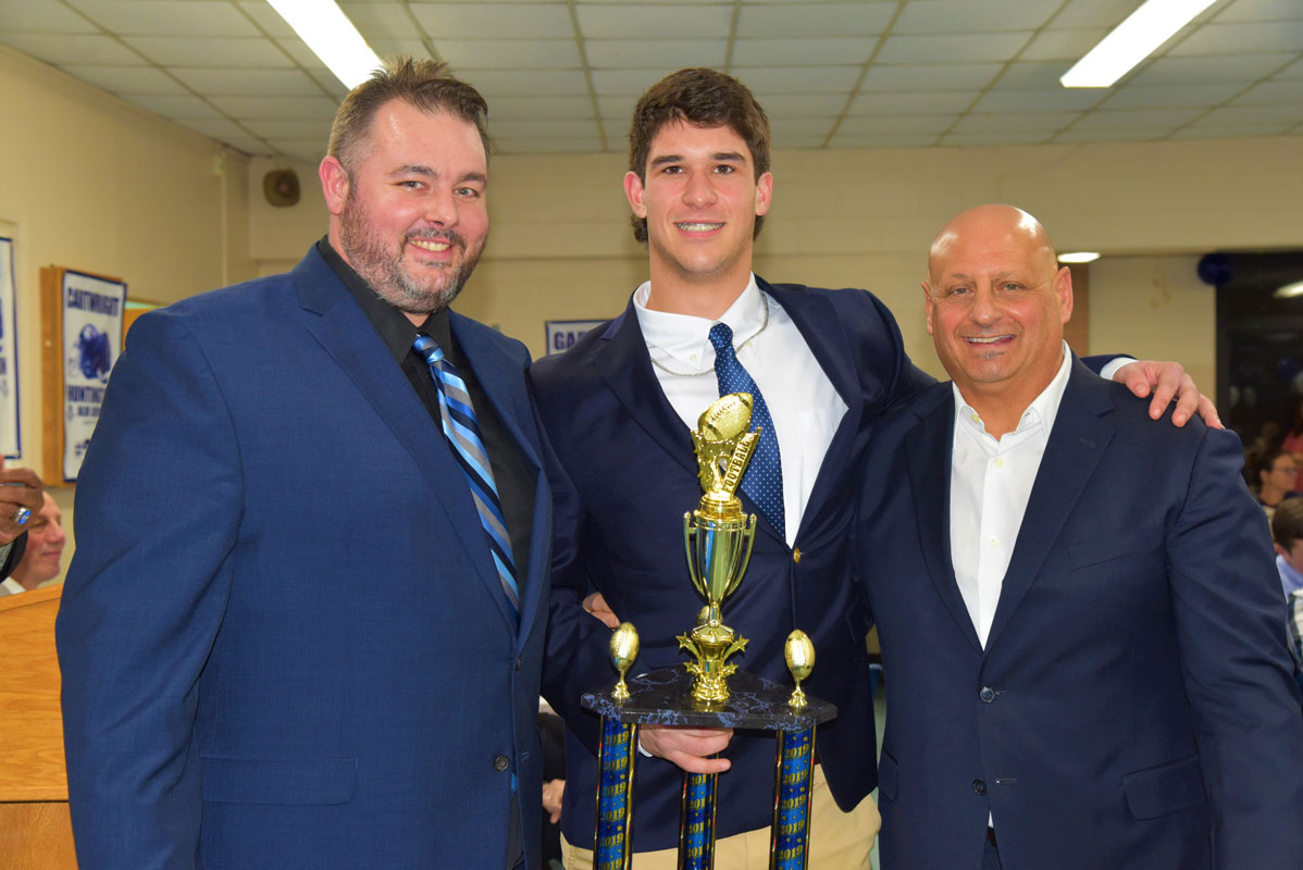 Huntington's 2018 Most Outstanding Defensive Player Award honoree Jon Koumas with coaches Kevin Graham and Steve Muller.