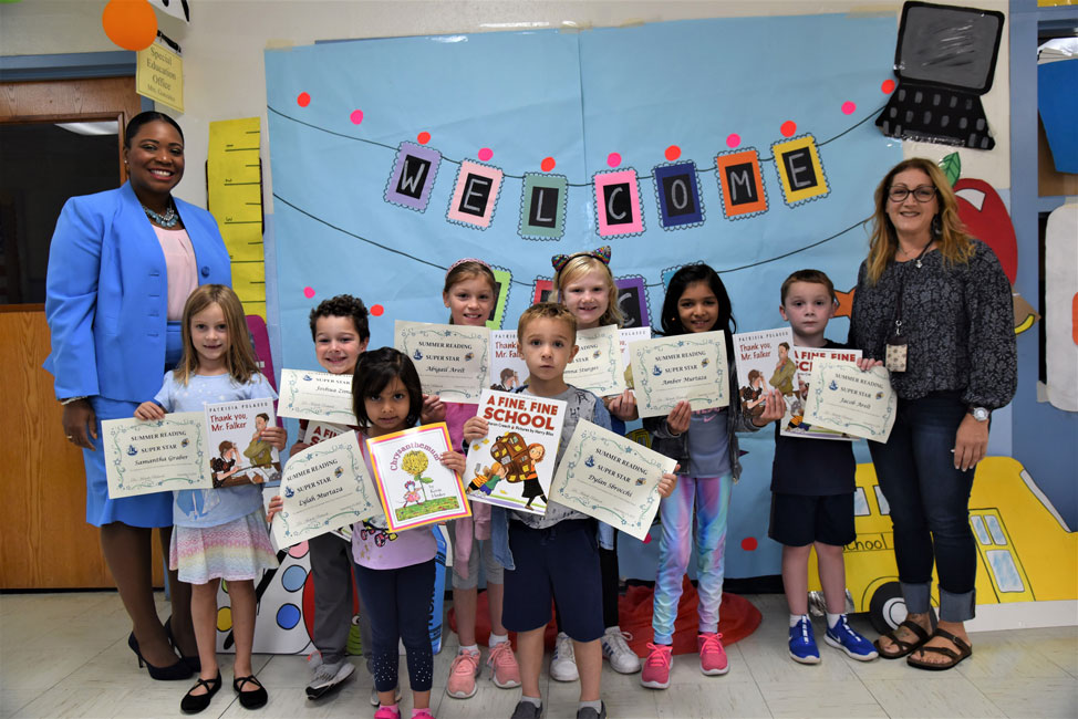 Principal Michelle Richards and librarian Sari Goldhaber with Washington School's top summer readers  