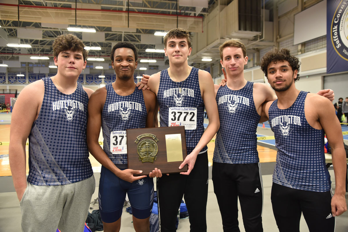 The Huntington boys' indoor track team captains hold the county championship plaque.  