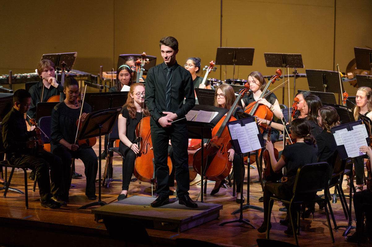 Julien Rentsch directs the high school orchestra as it performs one of his original compositions. (Darin Reed photo)
