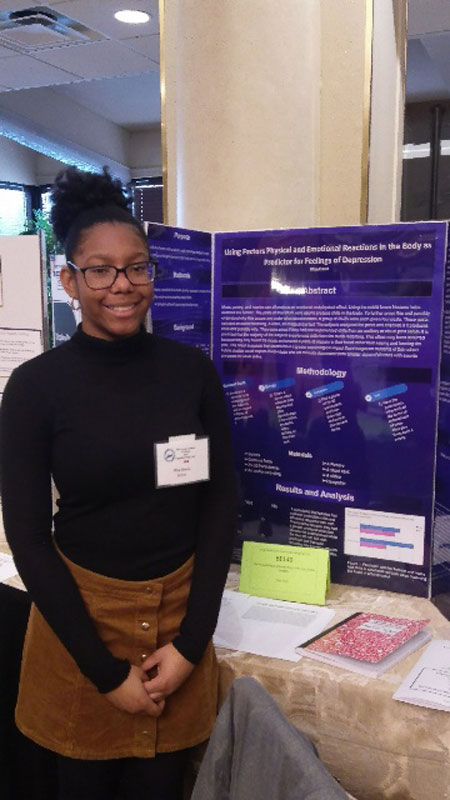Mya Davis stands near her project at the Crest Hollow Country Club in March 2018.